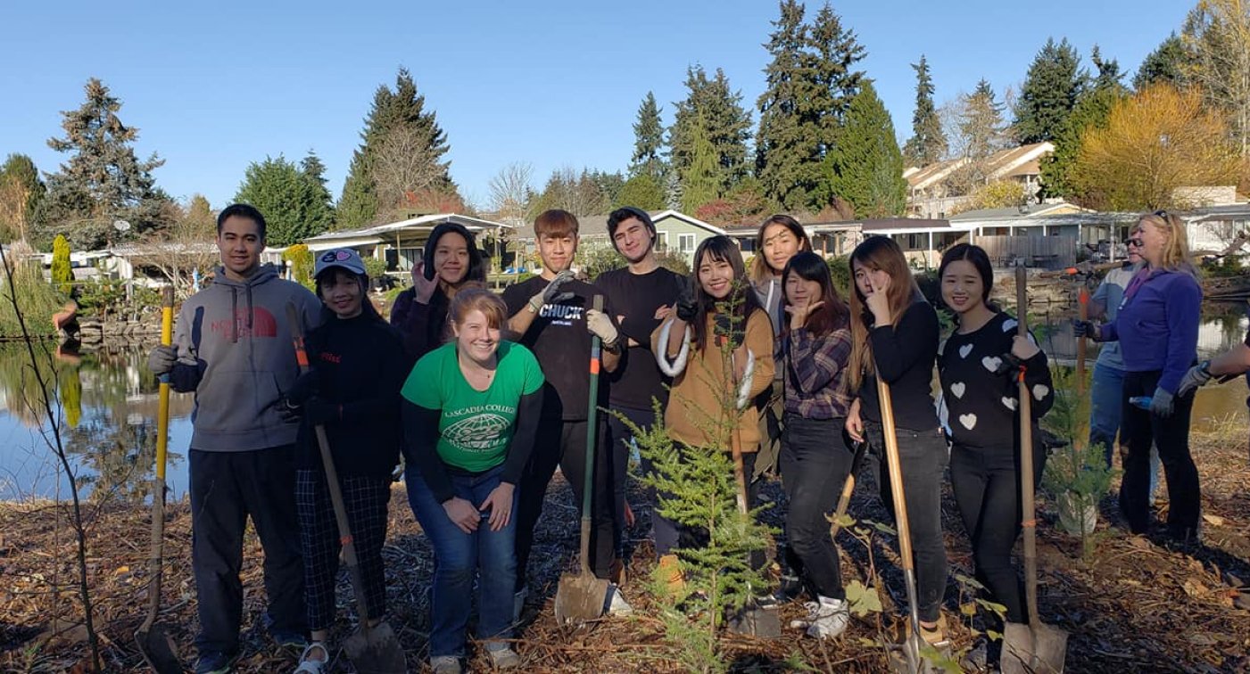 Students with shovels plant a tree